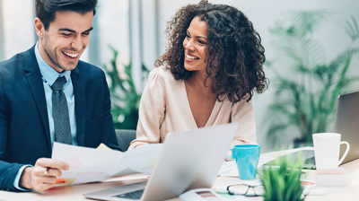 Office workers seated at a desk reviewing documents.