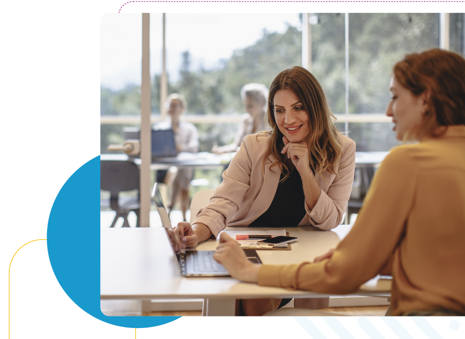 Two business women interacting with a laptop.